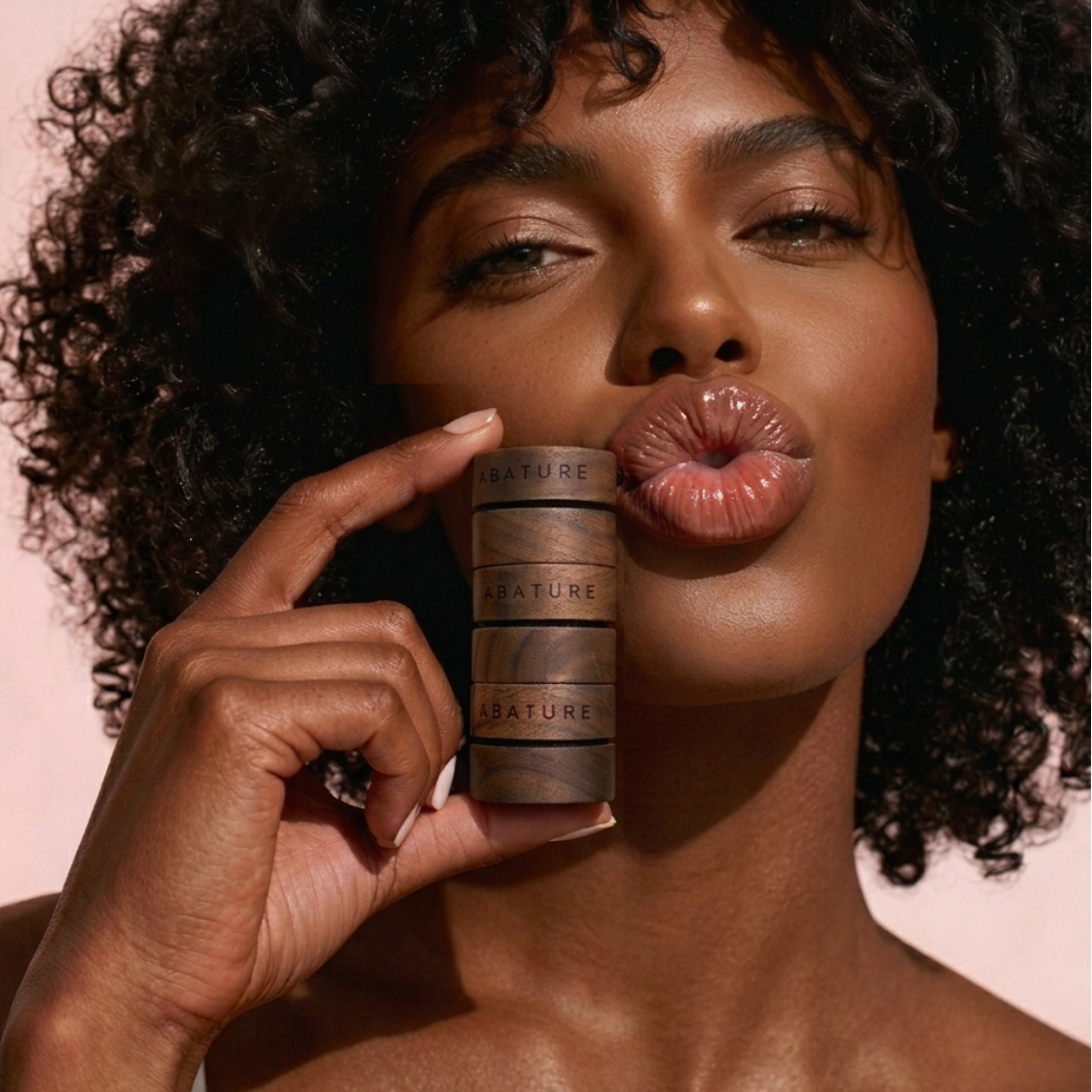 Woman holding a cylindrical product with 'Nature' branding against a pink background